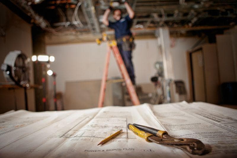 Licensed electrician installing a commercial panel in a restaurant kitchen build-out