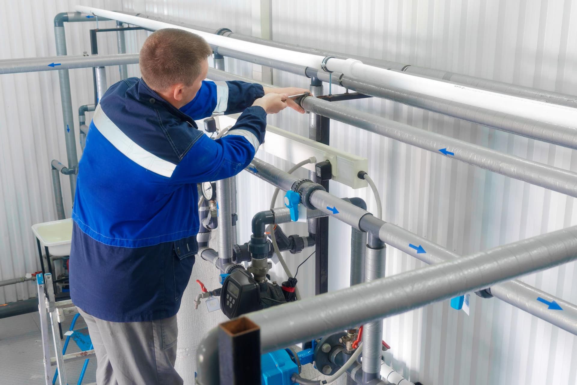 Plumber servicing commercial kitchen piping and equipment