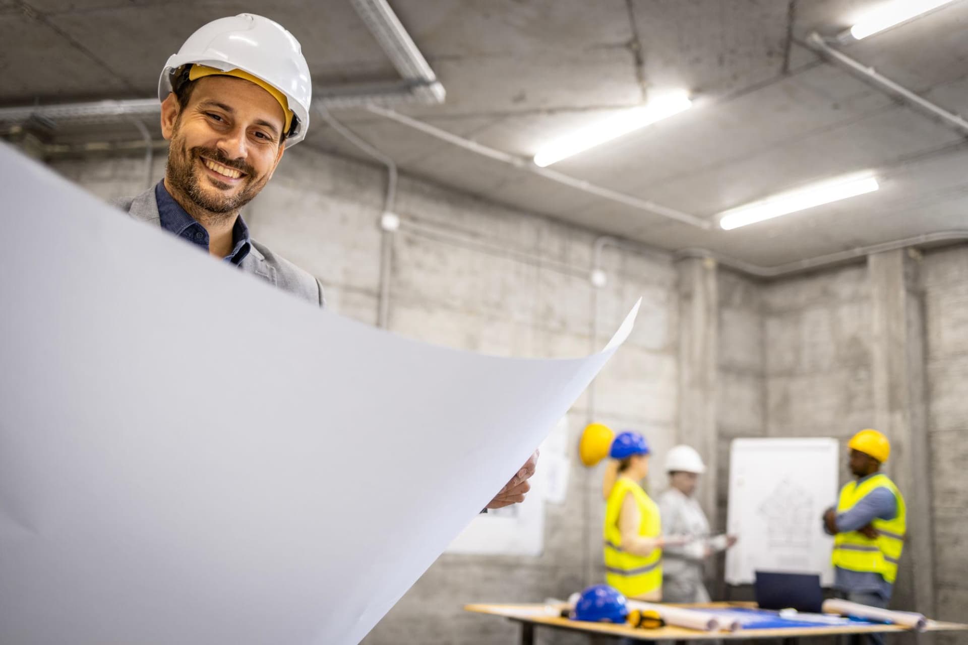Structural engineer holding blueprints at a construction site