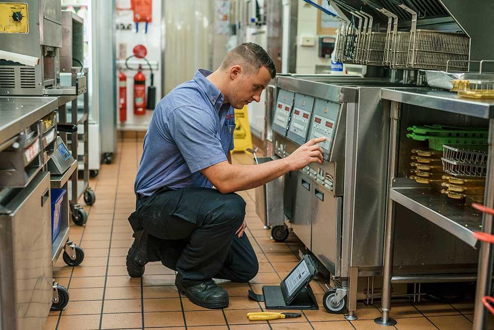 Technician servicing commercial kitchen equipment at Ocean Pearl Seafood