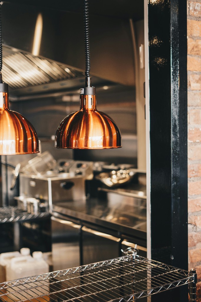 Copper heat lamps and commercial kitchen equipment at Spice & Smoke BBQ