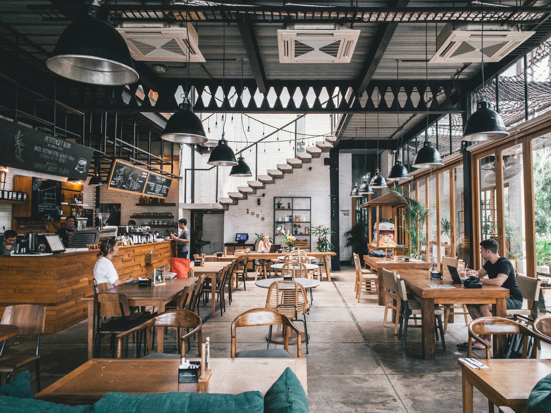 Modern restaurant interior with industrial lighting and open kitchen
