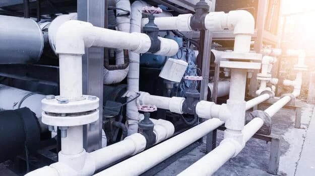 Plumber servicing commercial kitchen piping and equipment