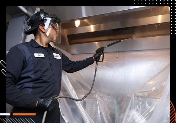Freshly cleaned commercial kitchen exhaust hood with gleaming stainless steel interior and clean grease filters