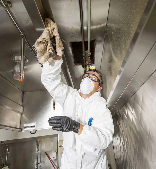 Freshly cleaned commercial kitchen exhaust hood with gleaming stainless steel interior and clean grease filters